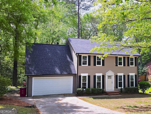 colonial house with an attached garage, concrete driveway, and roof with shingles