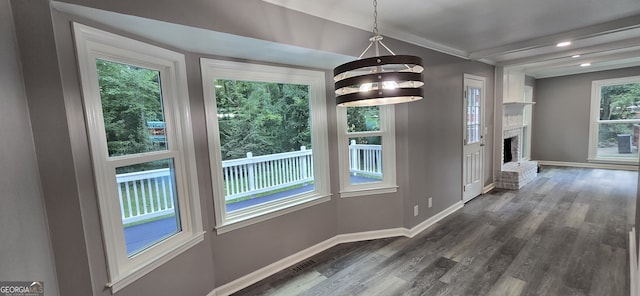 unfurnished dining area featuring dark wood-style floors, recessed lighting, a fireplace, and baseboards