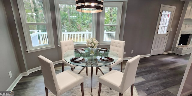 dining area with an inviting chandelier, baseboards, and dark wood finished floors