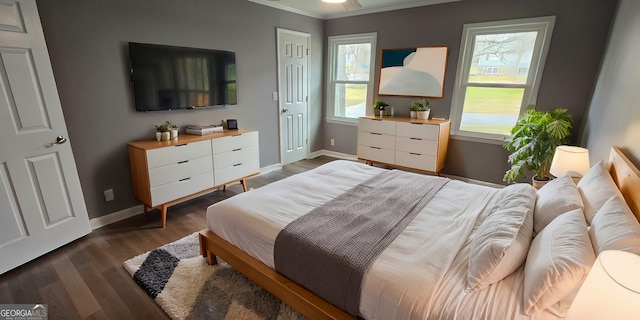 bedroom featuring ornamental molding, dark wood-type flooring, and baseboards