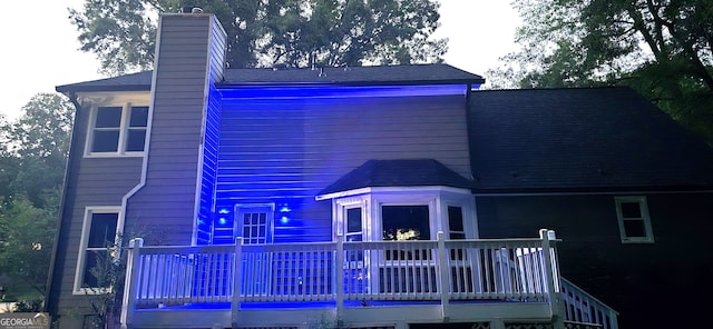 rear view of property featuring a deck and a chimney