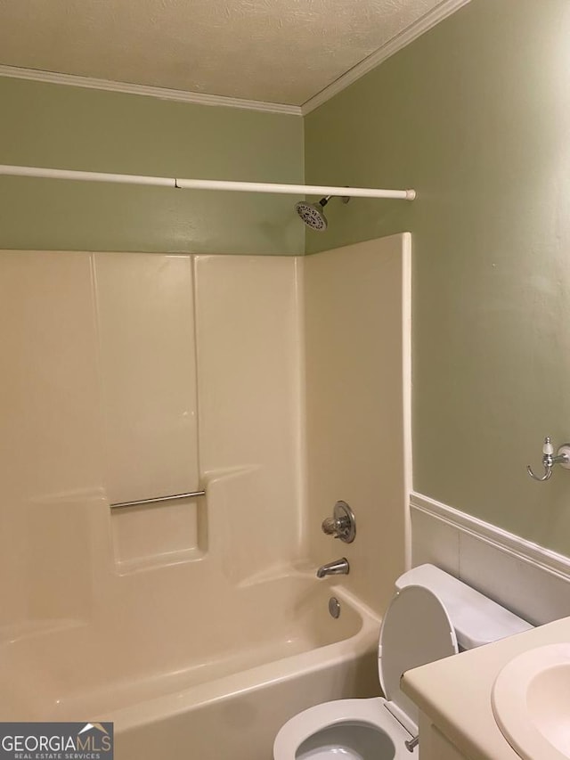 full bathroom with vanity, ornamental molding, a textured ceiling, shower / bathtub combination, and toilet