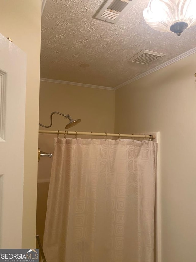 bathroom featuring crown molding and a textured ceiling