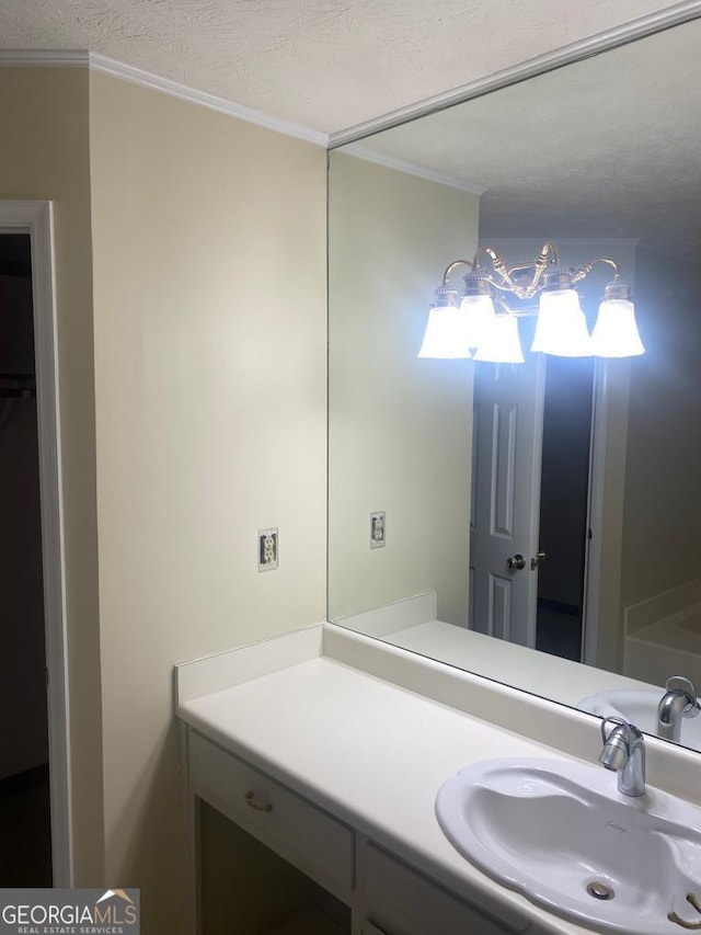 bathroom featuring crown molding, vanity, and a textured ceiling