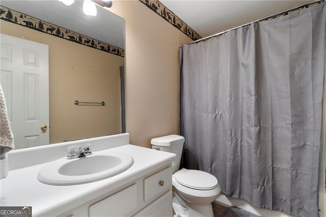 bathroom with a shower with shower curtain, vanity, and toilet