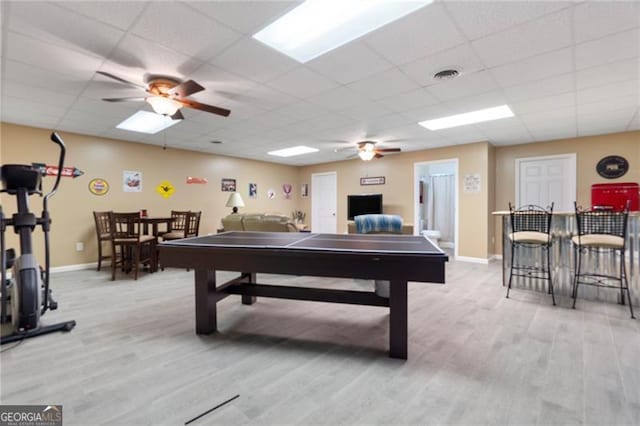 game room with a drop ceiling, ceiling fan, and light wood-type flooring