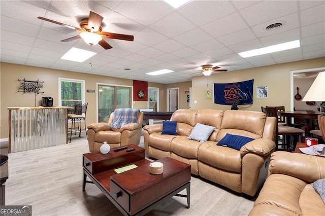 living room featuring a drop ceiling and light hardwood / wood-style floors