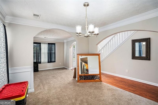 living room featuring a textured ceiling, carpet floors, an inviting chandelier, and crown molding