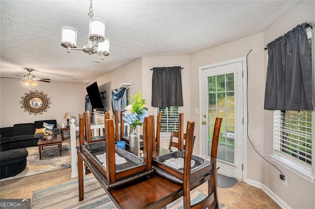 dining room featuring a textured ceiling, light tile patterned floors, and ceiling fan with notable chandelier