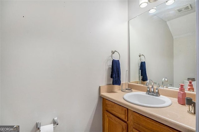 bathroom with vanity and lofted ceiling