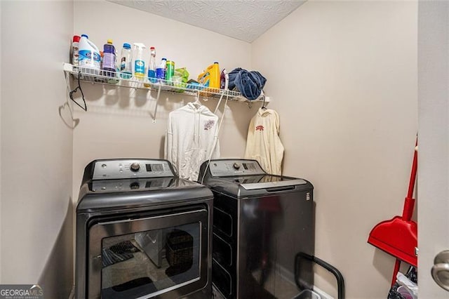 laundry room with a textured ceiling and separate washer and dryer