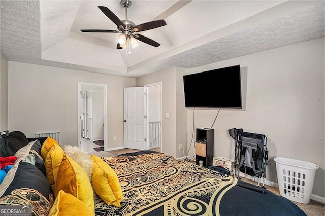 bedroom featuring ceiling fan, a raised ceiling, and carpet floors