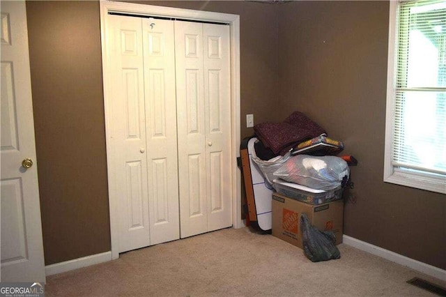 carpeted bedroom with multiple windows and a closet