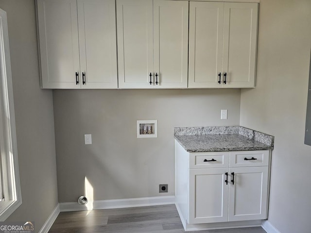 laundry area with electric dryer hookup, cabinets, washer hookup, and hardwood / wood-style flooring