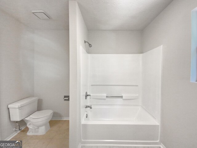 bathroom featuring toilet, tile patterned flooring, a textured ceiling, and tub / shower combination