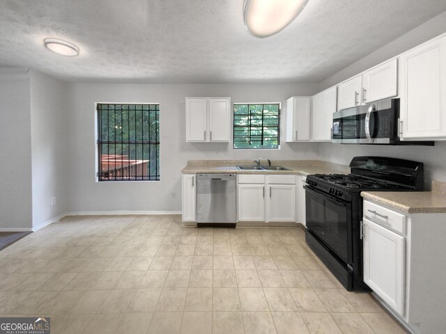 kitchen featuring a textured ceiling, white cabinetry, sink, and appliances with stainless steel finishes