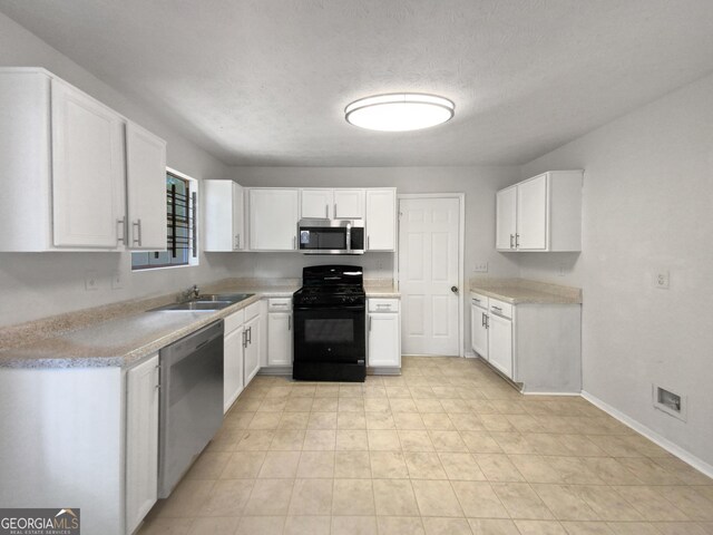 kitchen featuring sink, white cabinets, a textured ceiling, and appliances with stainless steel finishes