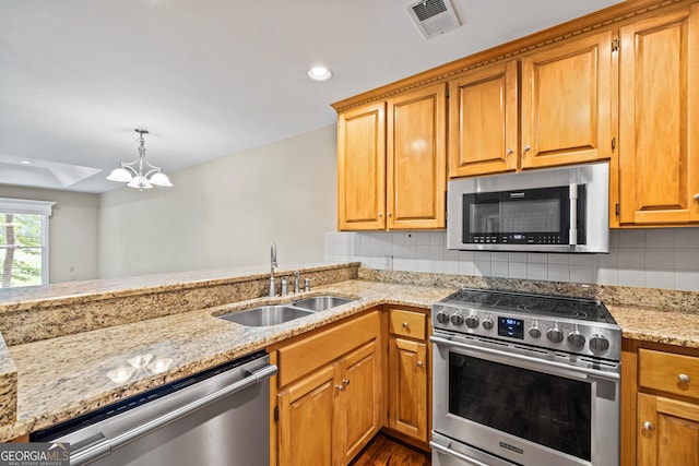 kitchen featuring sink, hanging light fixtures, stainless steel appliances, backsplash, and a chandelier