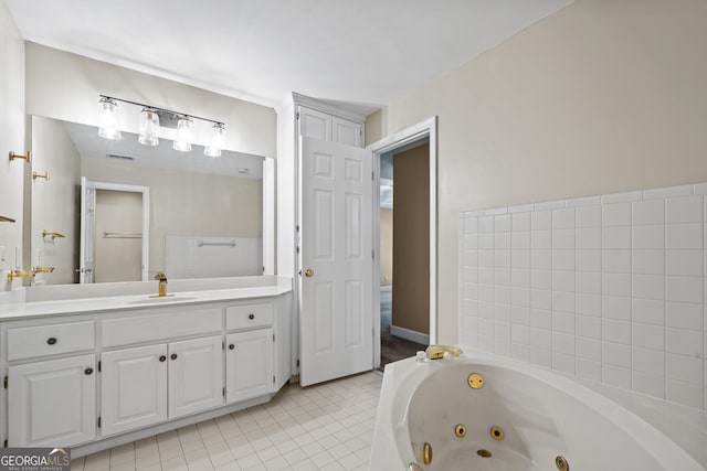 bathroom featuring tiled bath, tile patterned flooring, and vanity