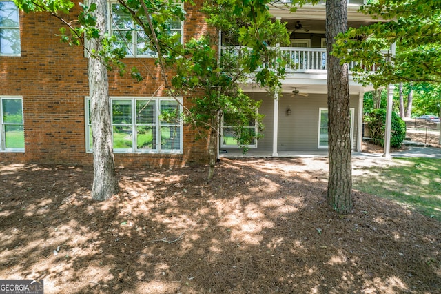 rear view of house featuring a balcony and ceiling fan