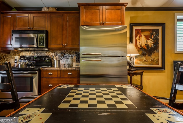 kitchen with decorative backsplash, crown molding, and appliances with stainless steel finishes