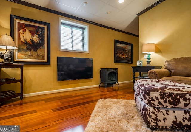 interior space with hardwood / wood-style flooring, a wood stove, and ornamental molding