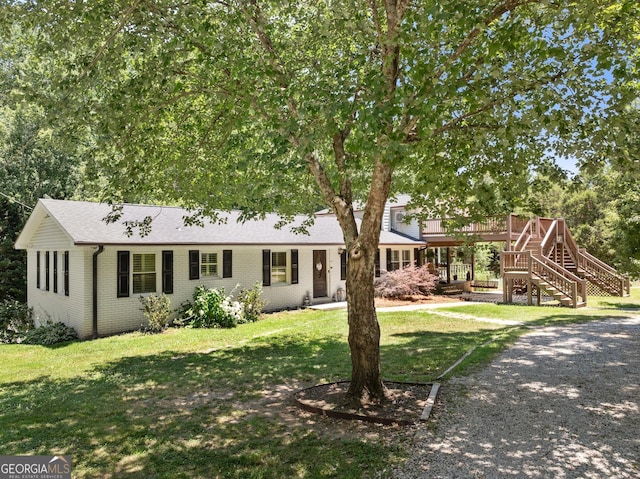 view of front of property featuring a front lawn and a deck