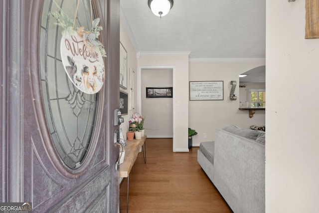 entryway featuring a textured ceiling, light hardwood / wood-style flooring, and ornamental molding