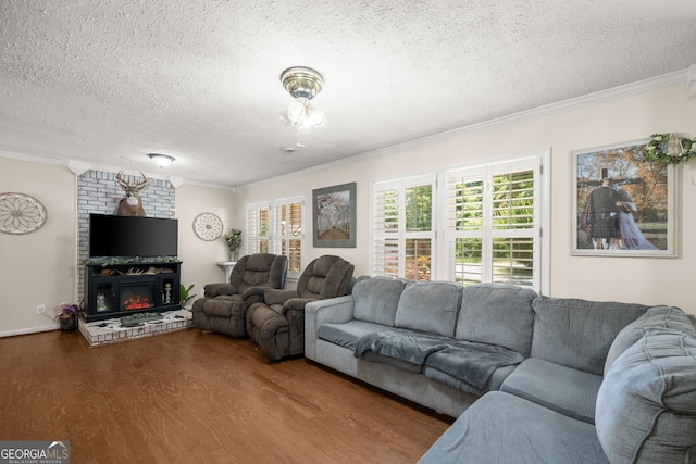 living room featuring hardwood / wood-style floors, a large fireplace, a textured ceiling, and ornamental molding