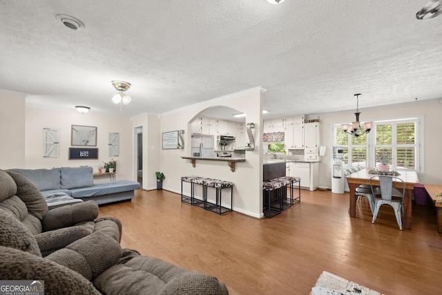 living room with dark hardwood / wood-style flooring, a textured ceiling, and an inviting chandelier