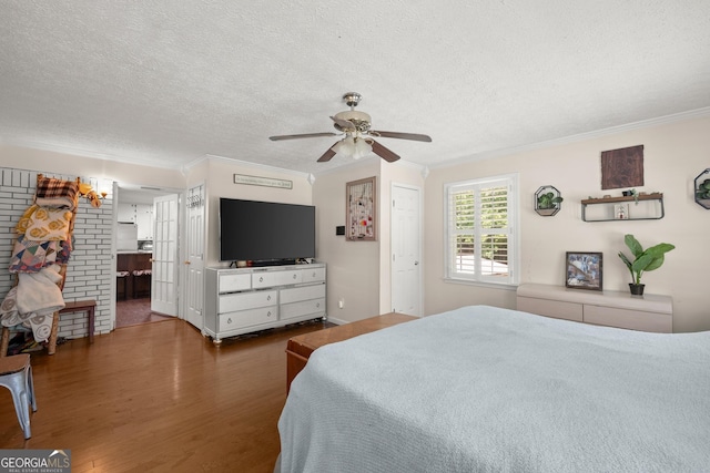 bedroom featuring connected bathroom, ceiling fan, wood-type flooring, and a textured ceiling