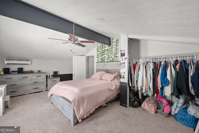 bedroom featuring a wall mounted AC, a textured ceiling, lofted ceiling with beams, and ceiling fan