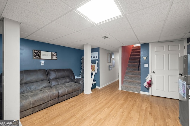 living room featuring a paneled ceiling and hardwood / wood-style flooring