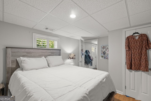 bedroom featuring a paneled ceiling and hardwood / wood-style floors