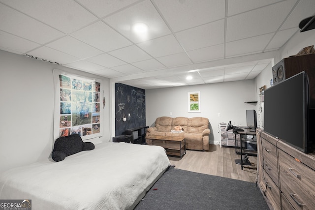 bedroom with light hardwood / wood-style flooring and a drop ceiling