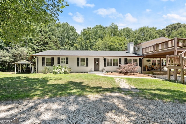 ranch-style house with a wooden deck and a front lawn