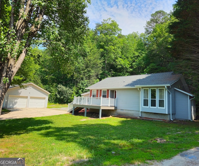 view of front of home with a wooden deck, a front lawn, a garage, and an outdoor structure