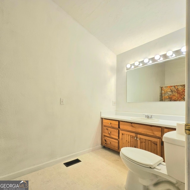 bathroom with tile floors, vanity, and toilet