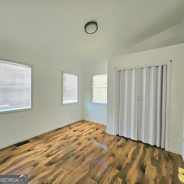 spare room with lofted ceiling and hardwood / wood-style flooring