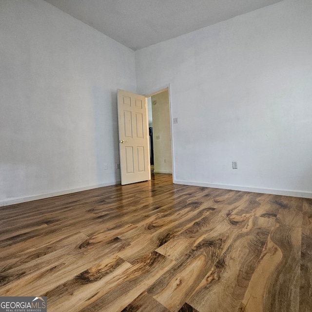 empty room with dark hardwood / wood-style flooring