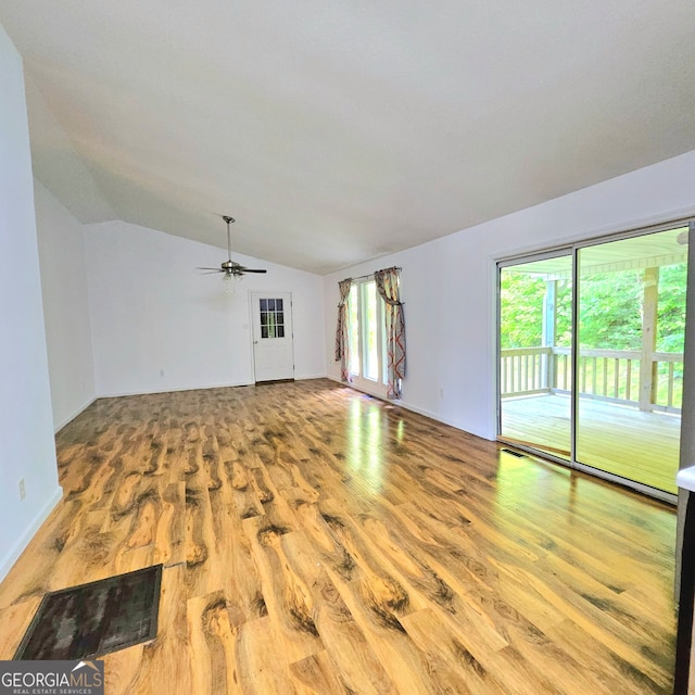 unfurnished living room featuring ceiling fan, vaulted ceiling, and wood-type flooring