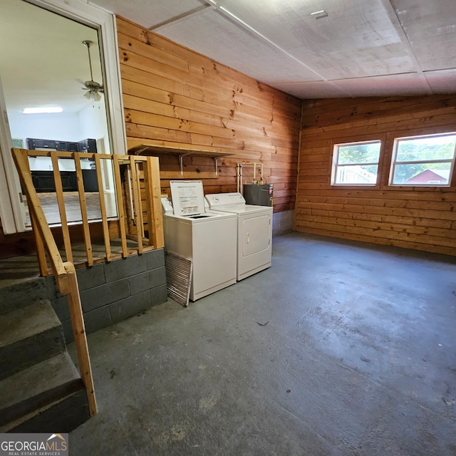 interior space with ceiling fan, separate washer and dryer, and wood walls