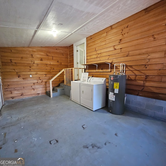 clothes washing area with wooden walls, electric water heater, and independent washer and dryer