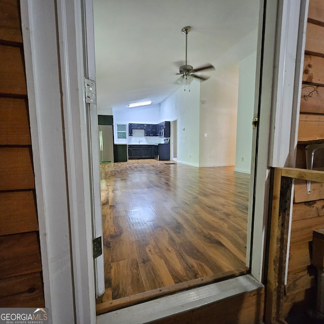 interior space with ceiling fan, stainless steel fridge, and wood-type flooring