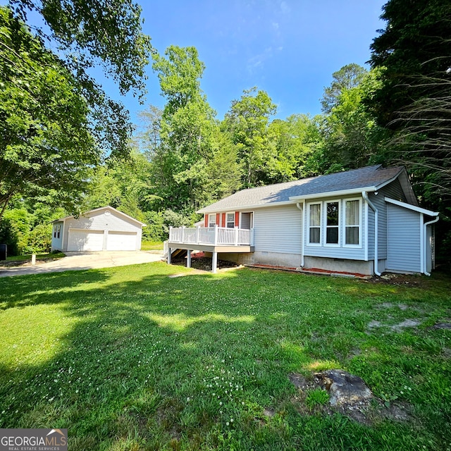 exterior space with a deck, a front yard, a garage, and an outdoor structure