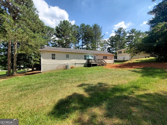 rear view of property with a deck and a lawn