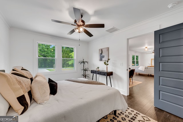 bedroom with dark hardwood / wood-style flooring, ceiling fan, and crown molding