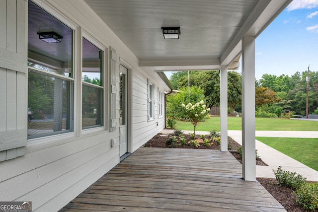 deck with covered porch and a yard