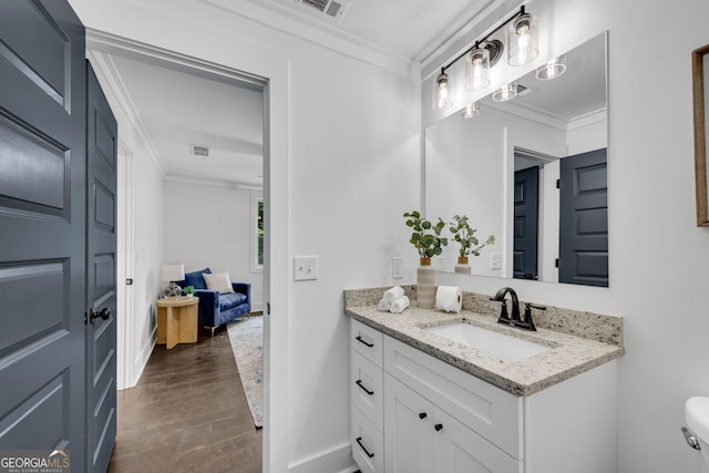 bathroom featuring crown molding, vanity, and wood-type flooring