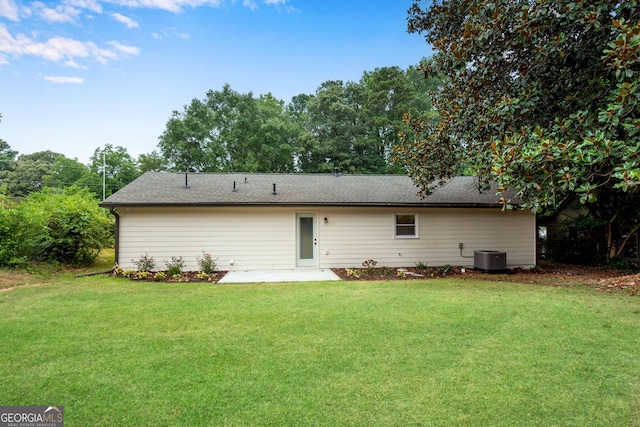 back of house featuring a lawn, cooling unit, and a patio